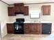 Well-appointed kitchen with brown cabinetry, sleek black appliances, and a stainless-steel sink at 9160 Sw 31St Avenue Rd, Ocala, FL 34476