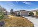 Inviting single-story home showcasing a manicured lawn, tidy landscaping, and a spacious two-car garage at 9858 Sw 75Th Street Rd, Ocala, FL 34481