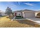 Charming single-story home featuring a well-maintained lawn, landscaped bushes, and a red front door at 9858 Sw 75Th Street Rd, Ocala, FL 34481