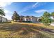 Charming single-story home featuring a well-maintained lawn, landscaped bushes, and a red front door at 9858 Sw 75Th Street Rd, Ocala, FL 34481