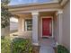 Inviting front porch with a striking red door framed by elegant columns and landscaping at 9858 Sw 75Th Street Rd, Ocala, FL 34481