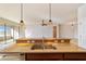 Kitchen island with stainless steel sink, granite countertops, and modern pendant lighting at 9858 Sw 75Th Street Rd, Ocala, FL 34481