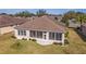 Wide angle view of backyard, home with sunroom, and manicured lawn at 9858 Sw 75Th Street Rd, Ocala, FL 34481