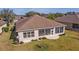 Wide angle view of backyard, home with sunroom, and manicured landscaping at 9858 Sw 75Th Street Rd, Ocala, FL 34481