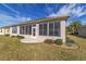 Home exterior showcases a screened sunroom with a door, complemented by lush landscaping at 9858 Sw 75Th Street Rd, Ocala, FL 34481