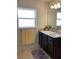 Bathroom with dark vanity, single sink, and window at 10 Spruce Pass, Ocala, FL 34472