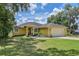 Beautiful yellow house with a two-car garage and well-manicured lawn at 10170 Se 106Th Ln, Belleview, FL 34420