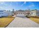 Inviting home exterior featuring a beautiful brick driveway and a well-kept lawn, offering a warm and welcoming curb appeal at 10306 Sw 99Th Ln, Ocala, FL 34481