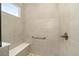 Shower featuring a built-in bench, grab bar, and tiled walls at 10306 Sw 99Th Ln, Ocala, FL 34481