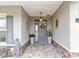 Front entry with gray door, stone accents, and potted plants at 10339 Sw 96Th Ln, Ocala, FL 34481