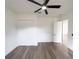 Bedroom with wood-look floors, white walls, closet doors, and a ceiling fan at 12217 Sw 67Th Ln, Ocala, FL 34481