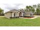 Front exterior of single-Gathering home with stone accents and a red door at 12217 Sw 67Th Ln, Ocala, FL 34481