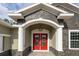 Stunning front entrance with red double doors and stone accents showcasing modern design and curb appeal at 12217 Sw 67Th Ln, Ocala, FL 34481