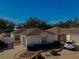 Tan one-story house with brown roof, gray garage door, and landscaped yard at 17074 Se 75Th Wickson Ct, The Villages, FL 32162