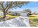 Gray house with white accents, two-car garage, and landscaped yard at 17470 Se 115Th Terrace Rd, Summerfield, FL 34491