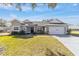 Gray house with white accents, two-car garage, and landscaped yard at 17470 Se 115Th Terrace Rd, Summerfield, FL 34491