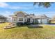 Gray house with white accents, two-car garage, and landscaped yard at 17470 Se 115Th Terrace Rd, Summerfield, FL 34491