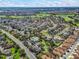 Aerial view of a community with houses, golf course, and pool at 1817 Hallandale Ln, The Villages, FL 32162