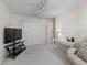 Bright bedroom with TV, closet, and seating area at 1817 Hallandale Ln, The Villages, FL 32162