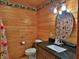 Charming bathroom with wood walls, granite vanity, and floral shower curtain at 1838 Sw 97Th Pl, Ocala, FL 34476