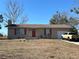 Single-story house with attached garage, red door, and a yard at 200 Nw 53 Ct, Ocala, FL 34482