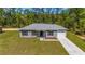 One story house, gray siding, two car garage, and driveway at 24130 Nw Banyan Ln, Dunnellon, FL 34431