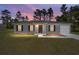 One-story house, gray siding, two-car garage. Lovely sunset view at 24130 Nw Banyan Ln, Dunnellon, FL 34431