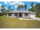 Gray siding one-story house with a two-car garage and landscaped yard at 24130 Nw Banyan Ln, Dunnellon, FL 34431