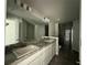 Bright bathroom with double sinks, granite countertops, a large mirror, and walk-in shower at 35 Locust Radial Cir, Ocala, FL 34472