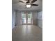 Open-concept living room with French doors to the back patio and neutral tile flooring at 3648 Se 31 Terrace Ter, Ocala, FL 34471