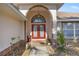 Home entrance with arched entryway and red double doors at 5459 Sw 84Th Ln, Ocala, FL 34476