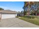 White two-car garage with driveway and landscaping at 5459 Sw 84Th Ln, Ocala, FL 34476