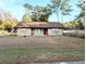 One-story house with brown roof, red door, and American flag at 5991 Nw 61St Ct, Ocala, FL 34482