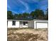 Single-story house with a white exterior, black accents, and a two-car garage at 6237 Sw 143Rd St, Ocala, FL 34473