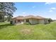 Rear view of a single-story home featuring a patio and lush lawn at 6558 Se 9Th Pl, Ocala, FL 34472