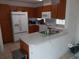 Kitchen with wood cabinets, white appliances and a breakfast bar at 7106 Sw 115Th Loop, Ocala, FL 34476