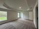 Spacious carpeted bedroom with tray ceiling, natural light, and backyard views at 77 Olive Dr, Ocala, FL 34472