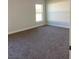 Spacious carpeted bedroom with large window and neutral walls at 77 Olive Dr, Ocala, FL 34472