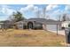 Single-story home with gray roof, screened porch, and front yard at 7727 Sw 102Nd Loop, Ocala, FL 34476