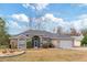 Tan single story house with gray roof, screened porch, and landscaped yard at 7727 Sw 102Nd Loop, Ocala, FL 34476