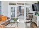 Living room with leather couch and access to screened porch at 7727 Sw 102Nd Loop, Ocala, FL 34476