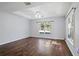 Living room with dark wood floors and large window at 7795 Sw 181St Cir, Dunnellon, FL 34432