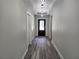 Hallway features wood floors and modern hanging light fixtures at 7799 Sw 132Nd Pl # 10, Ocala, FL 34473