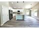 A bright kitchen is featured with white cabinets, a center island, stainless appliances, and modern lighting at 7799 Sw 132Nd Pl # 10, Ocala, FL 34473