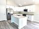 Bright kitchen featuring granite counters, island, stainless steel appliances, and modern light fixtures at 7799 Sw 132Nd Pl # 10, Ocala, FL 34473