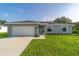 Gray house with white garage door, green front door, and landscaped lawn at 7865 Sw 143Rd Pl, Ocala, FL 34473