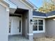 Front entrance of new construction home featuring a covered porch and white door at 8724 Se 157Th Pl, Summerfield, FL 34491