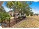 Landscaped backyard with a patio, lush greenery, and a black metal fence at 9176 Sw 93Rd Cir, Ocala, FL 34481