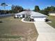 Single-story home with driveway, landscaped yard, and American flag at 9688 Sw 45Th Ave, Ocala, FL 34476