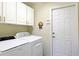 Bright laundry room with white cabinets and a Whirlpool washer and dryer at 9688 Sw 45Th Ave, Ocala, FL 34476